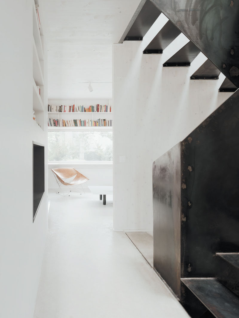 Dark black steel stairs stand out against the white walls in this modern home.