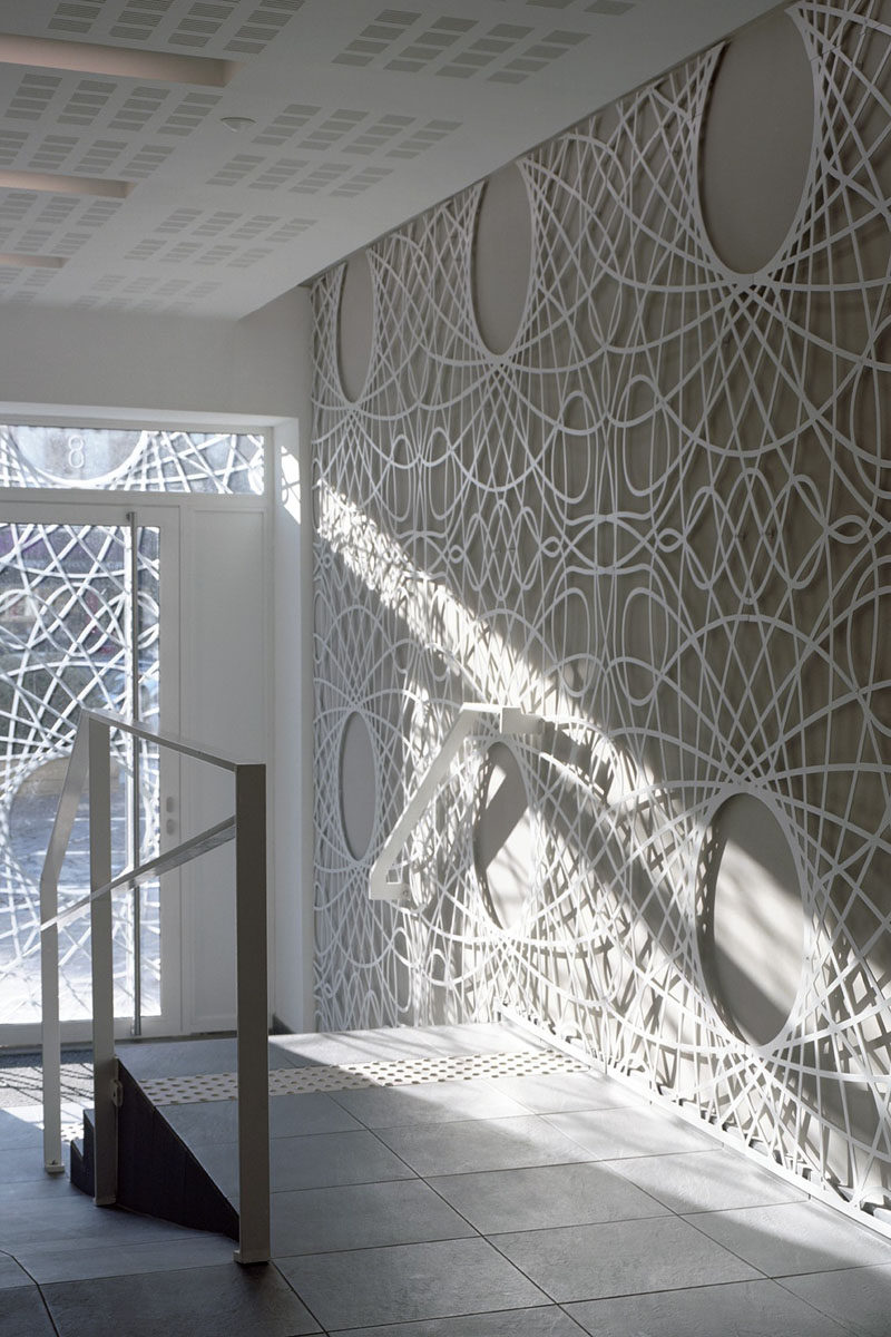 This lobby in this building features decorative concrete panels inspired by a pattern found on bank notes. The artistic panels also cover the facade of the building.