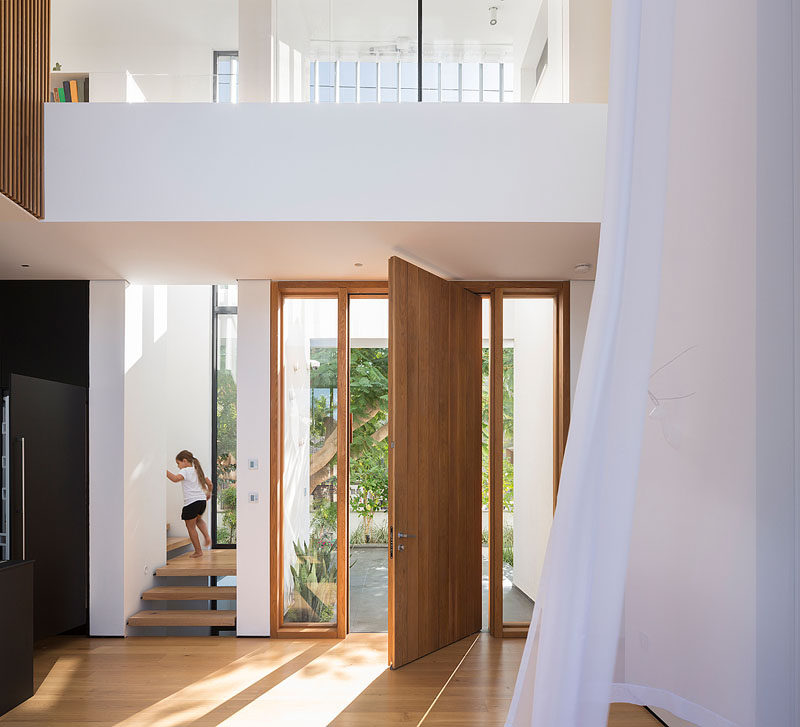 Welcoming you to this modern house is a wooden pivoting front door that opens to a double-height foyer.