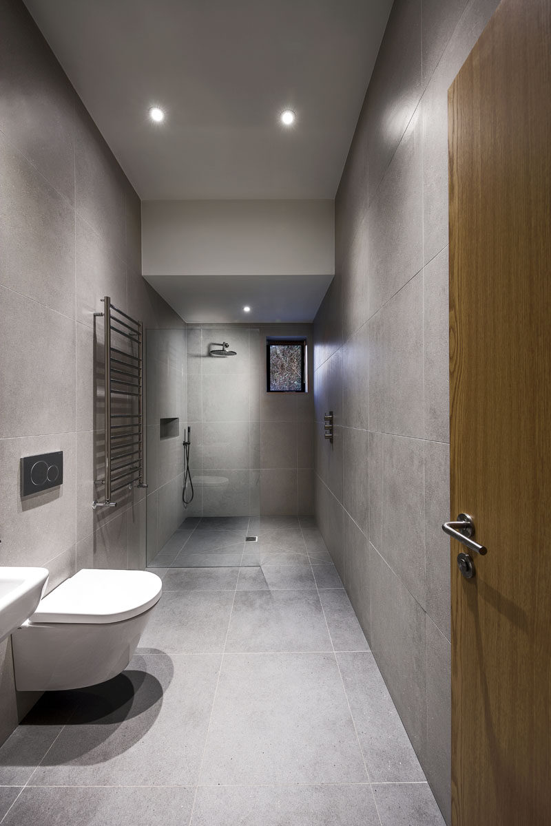 This modern bathroom features large grey tiles covering both the floor and walls.