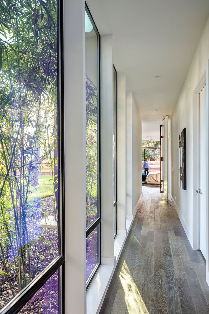 This modern hallway with floor-to-ceiling windows connects the master bedroom with the rest of the house.