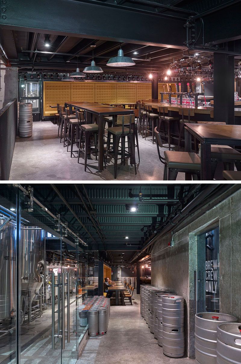 In this brew pub, yellow booth seating and bar stools around industrial style tables create various seating options, and large glass windows give people a glimpse into the brewing part of the pub.