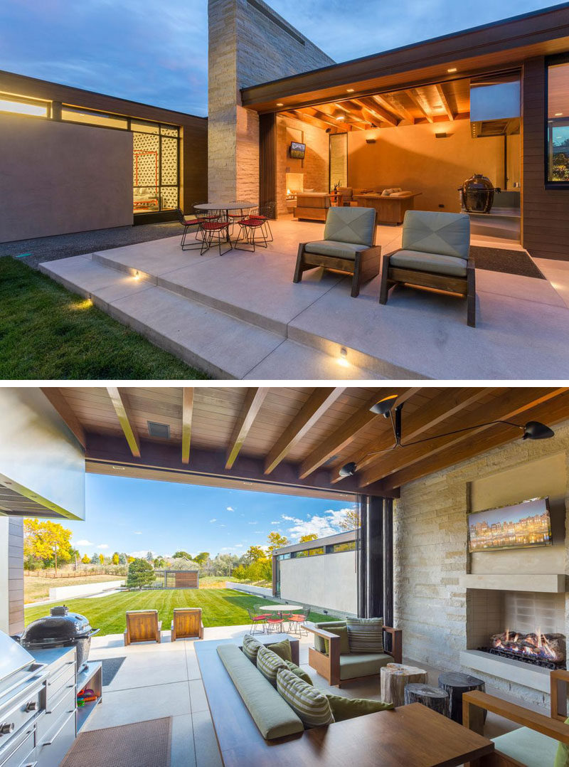 This contemporary home has a small indoor/outdoor living room with a fireplace, a dining area, and a barbeque.