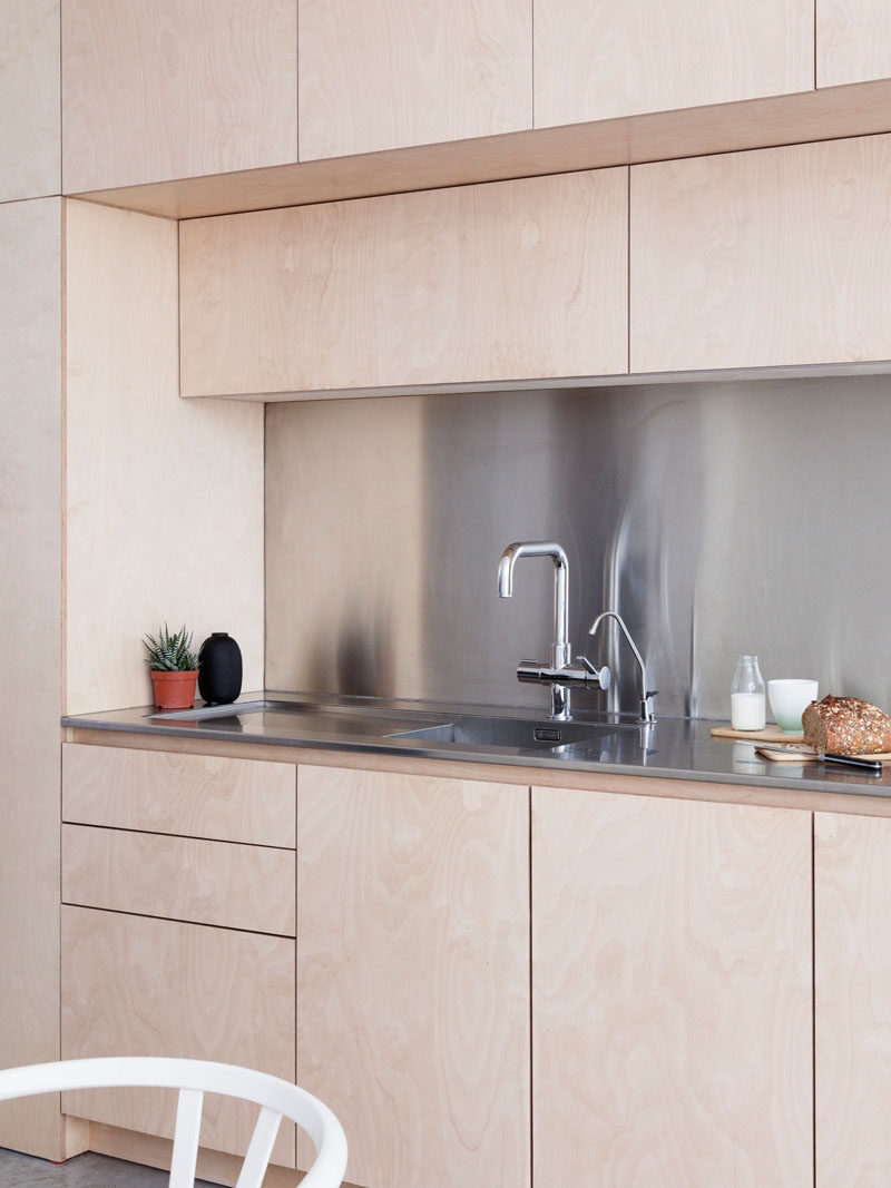 Kitchen Ideas - This contemporary kitchen has hardware-free light plywood kitchen cabinetry and a stainless steel backsplash and countertop.