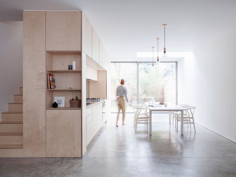 Kitchen Ideas - At the end of this contemporary wood kitchen, open shelving and stairs made from the same light wood as the kitchen cabinets helps to create a cohesive look within the home.