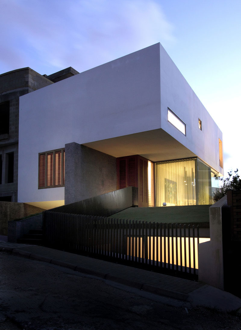 The clean lines, warm materials, and white exterior of this house look minimal, modern, and inviting.