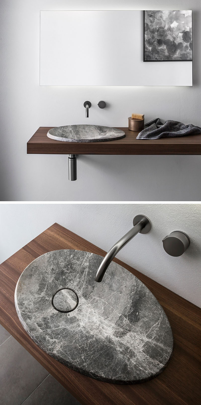 This modern bathroom sink made from natural stone sits on a floating wood vanity and has a simple stainless steel faucet.