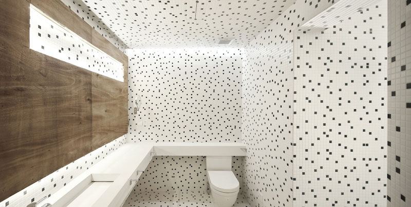 Bathroom Tile Idea - Use The Same Tile On The Floors And The Walls | Small black and white square tiles have been randomly arranged to create a polka dot look on the floors and walls of this bathroom.