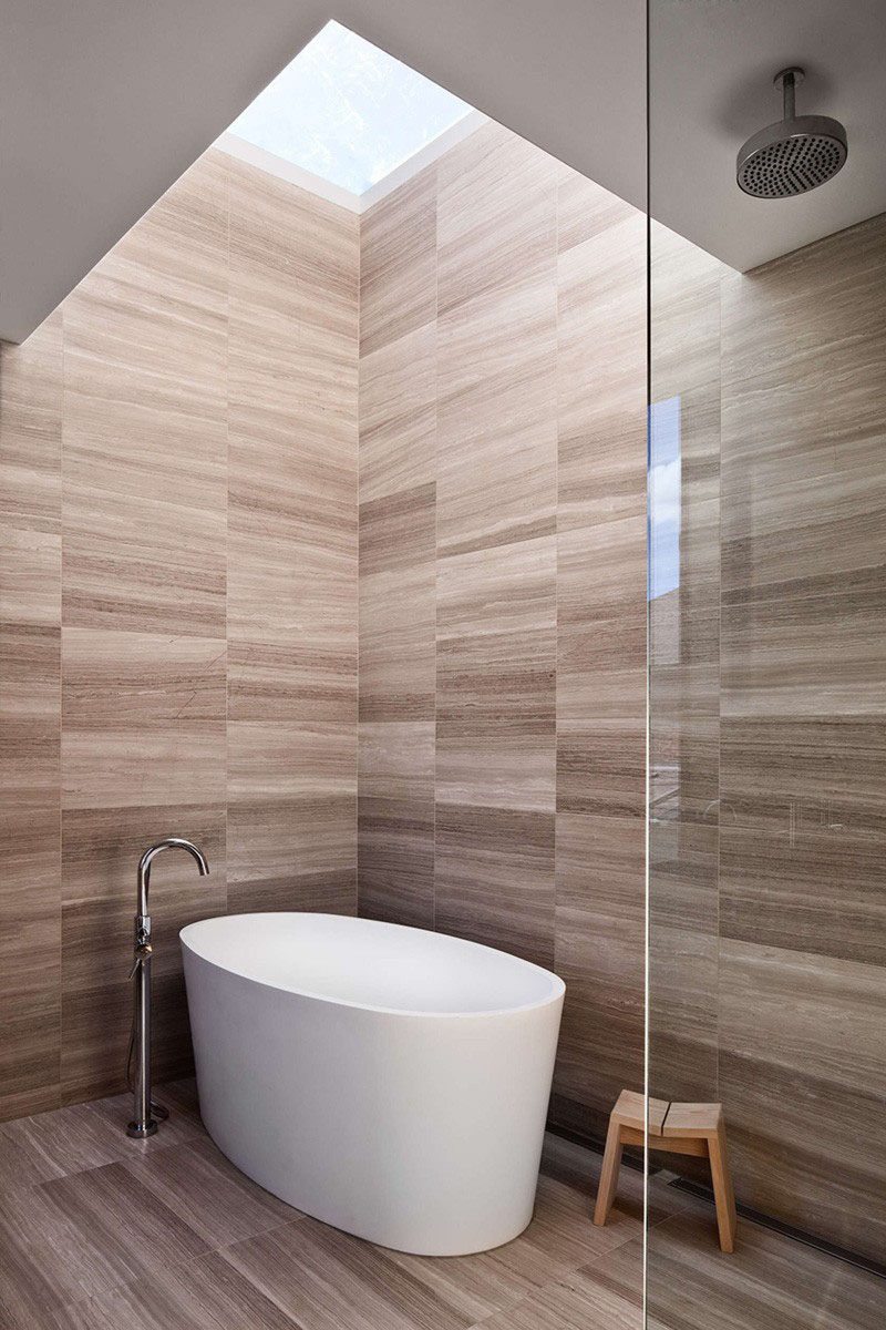 Bathroom Tile Idea - Use The Same Tile On The Floors And The Walls | The tiles on the walls and floors of this bathroom have an almost wood grain look to the them, giving the space a warm vibe.