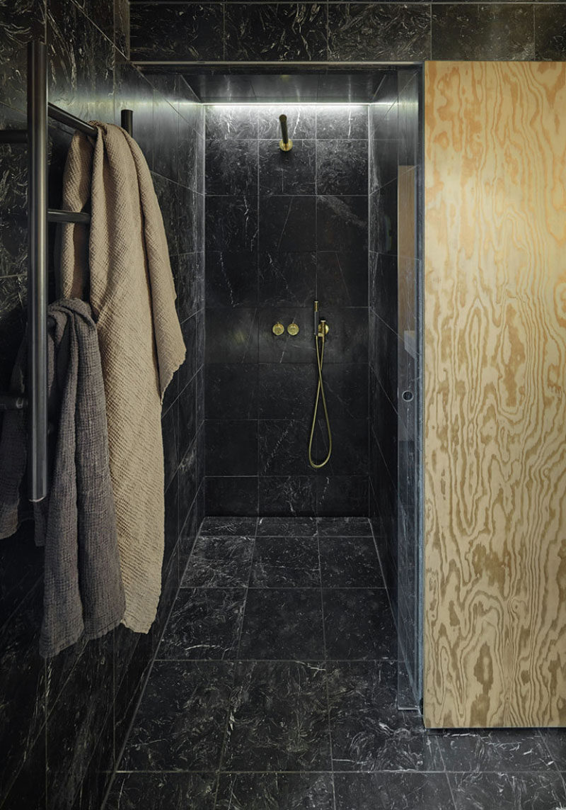 Bathroom Tile Idea - Use The Same Tile On The Floors And The Walls | Black marble tiles on the floor, walls, and ceiling of this small bathroom, coupled with the cold and black hardware give the space a luxurious look.