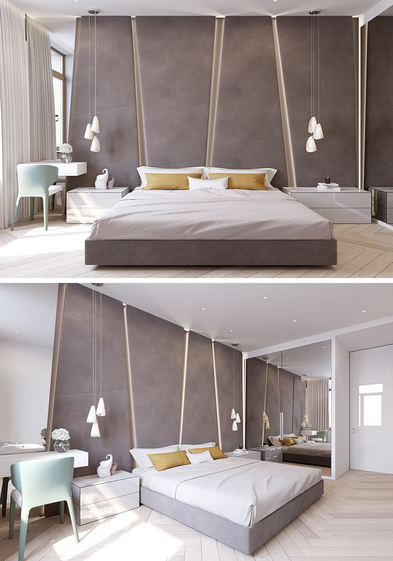 The grey upholstered headboard in this modern bedroom almost takes up the entire wall. The angular panels have hidden lighting between them giving the bedroom a soft glow.