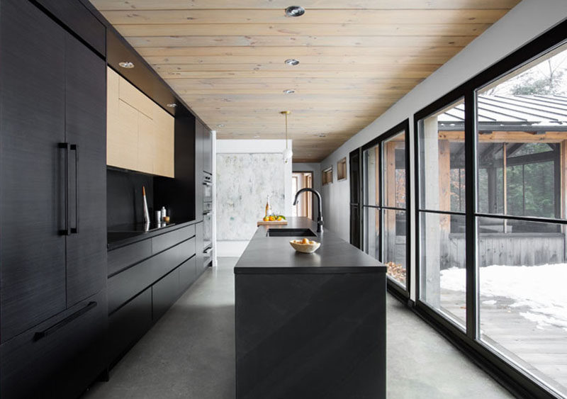 This modern black kitchen stands out against the light floors and white walls, and fits right in with all of the other black elements found in the home.