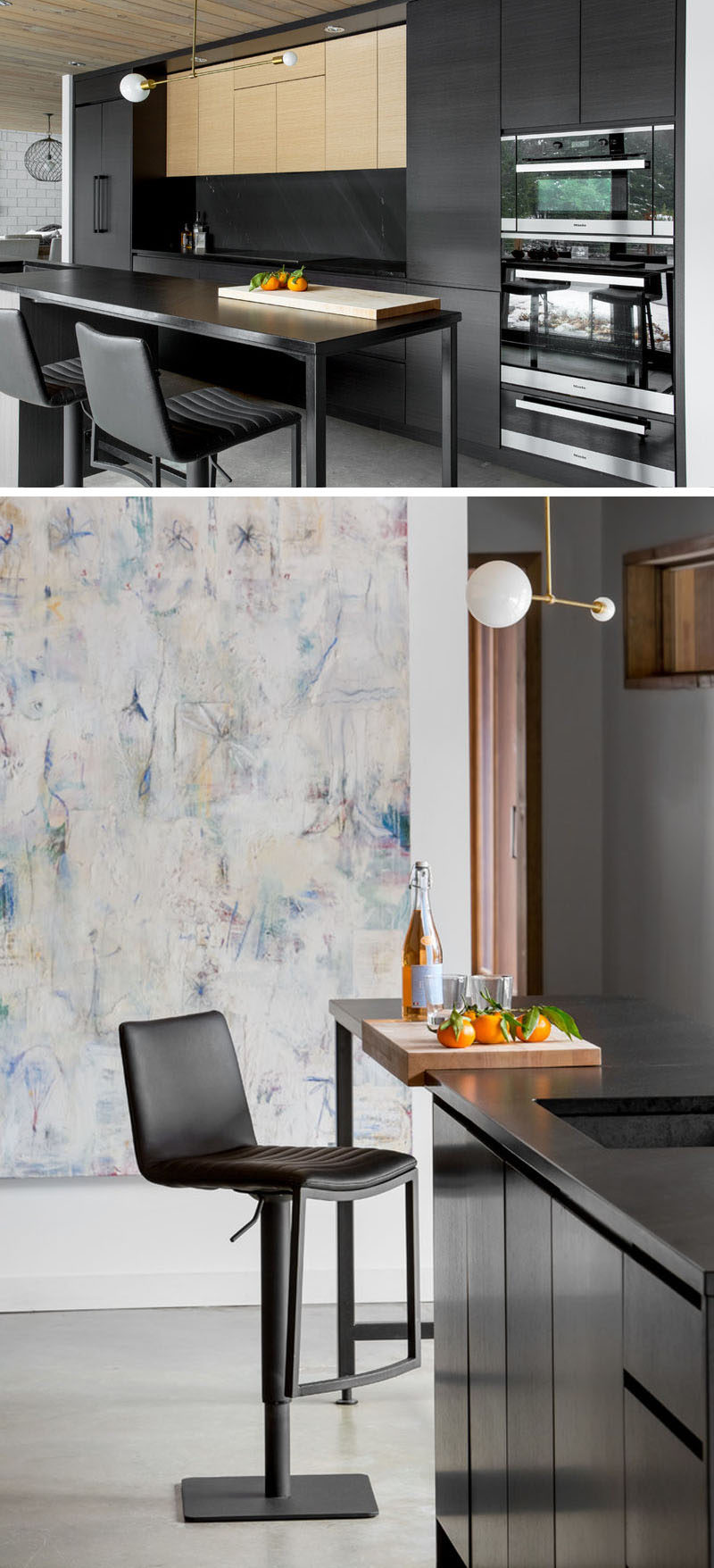 The extended countertop of this modern black kitchen can act as both additional counterspace as well as a bar where people can casually gather for a snack and a drink while dinner is still being prepared.