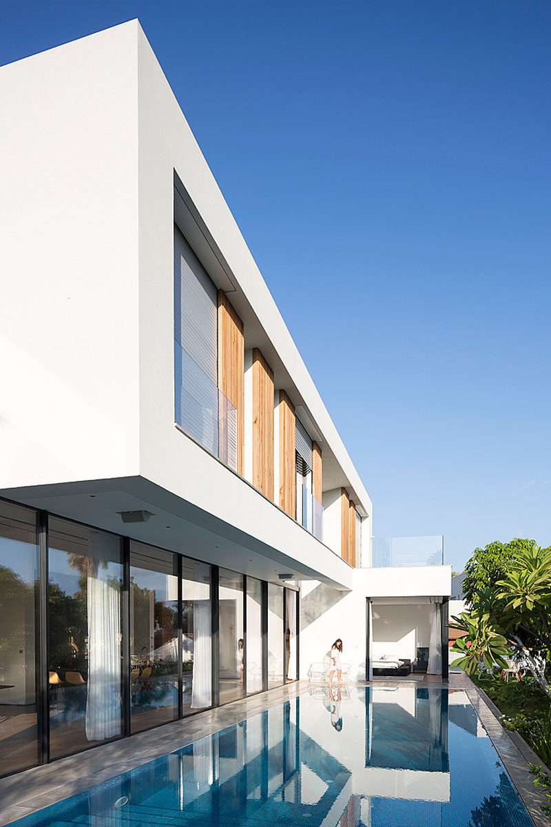 This modern house has been designed in an “L” shape that wraps around the swimming pool and has views of the park.