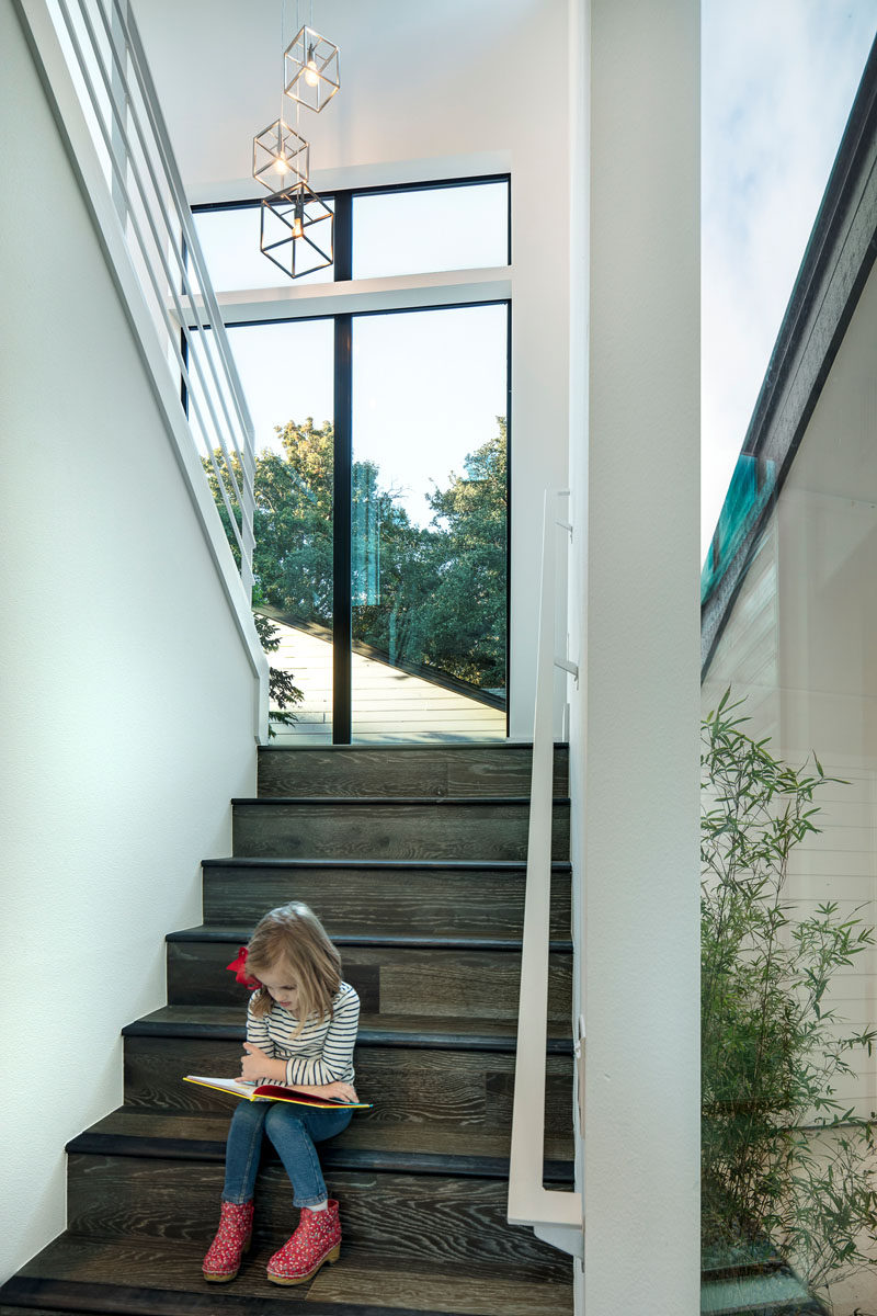 These wood and white stairs have lots of natural light from the large windows.