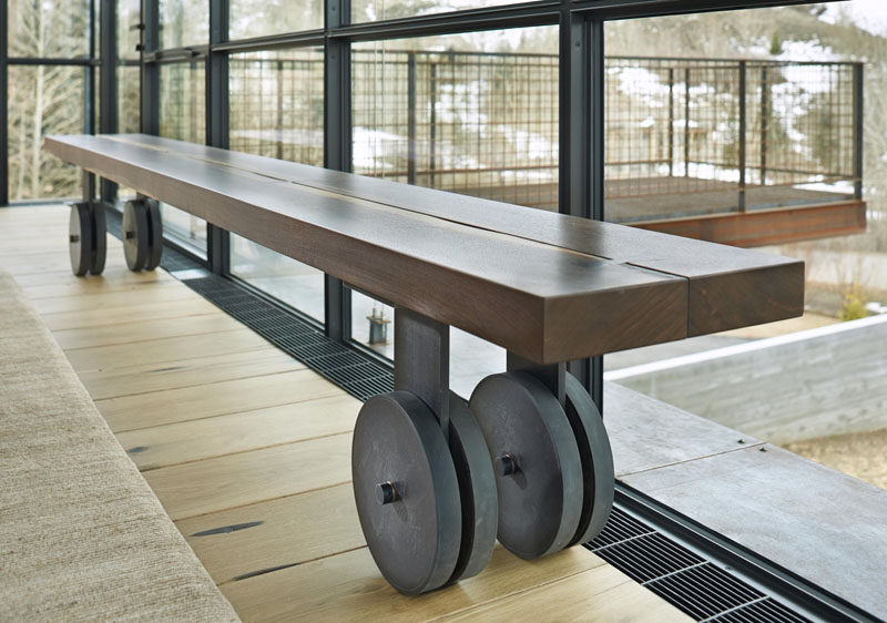 A wooden bench continues the industrial theme throughout the house with steel wheels attached to the legs.