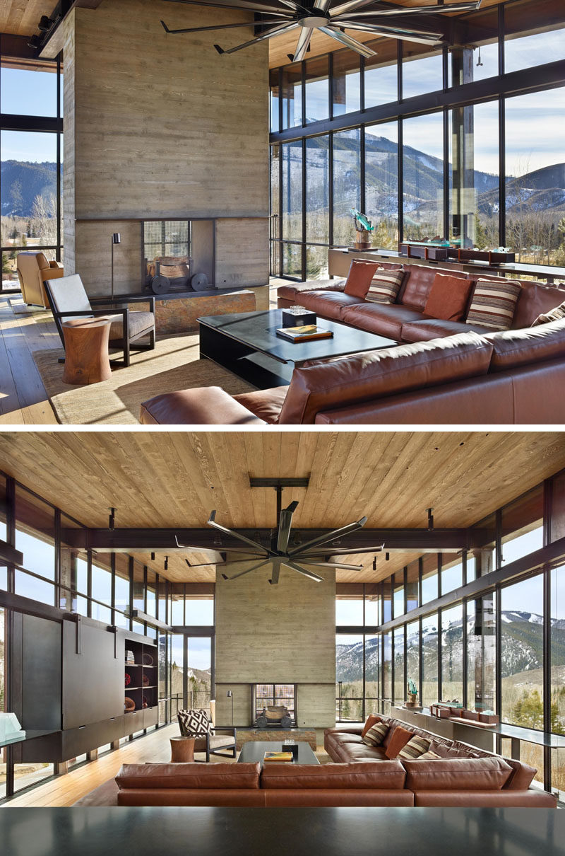 In this living room, a see-through fireplace can be enjoyed from both sides, and a large leather sofa has been paired with a curved-edge steel coffee table. Installed above the living room is a large fan with steel blades, ideal when trying to create a modern industrial space.