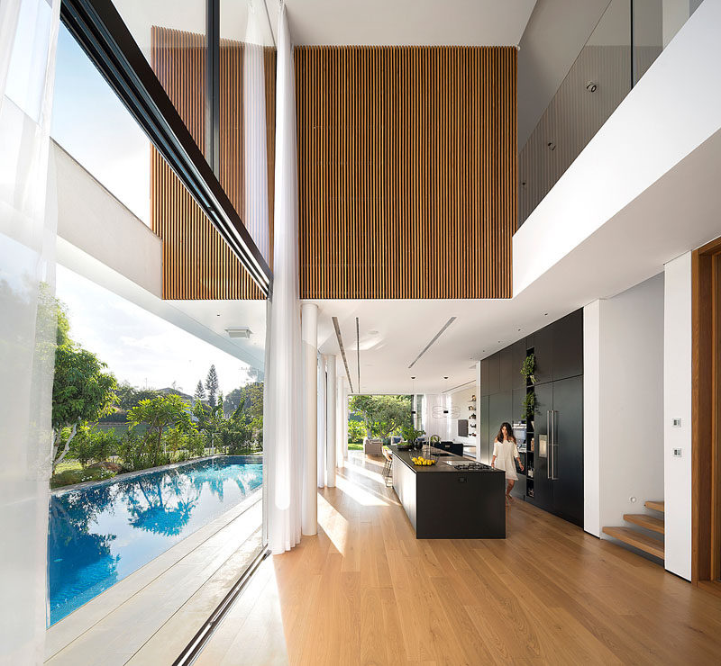 This modern house has a foyer with a double-height ceiling that provides views of a section of the upper floor that's covered in cedar.