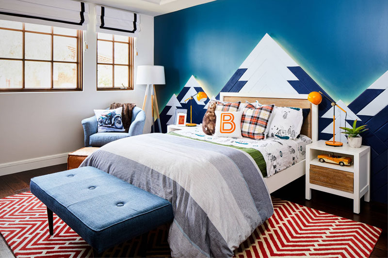 This kids bedroom design includes a mountain range as wall art, with hidden lighting that mimics the colors of the Northern Lights. 