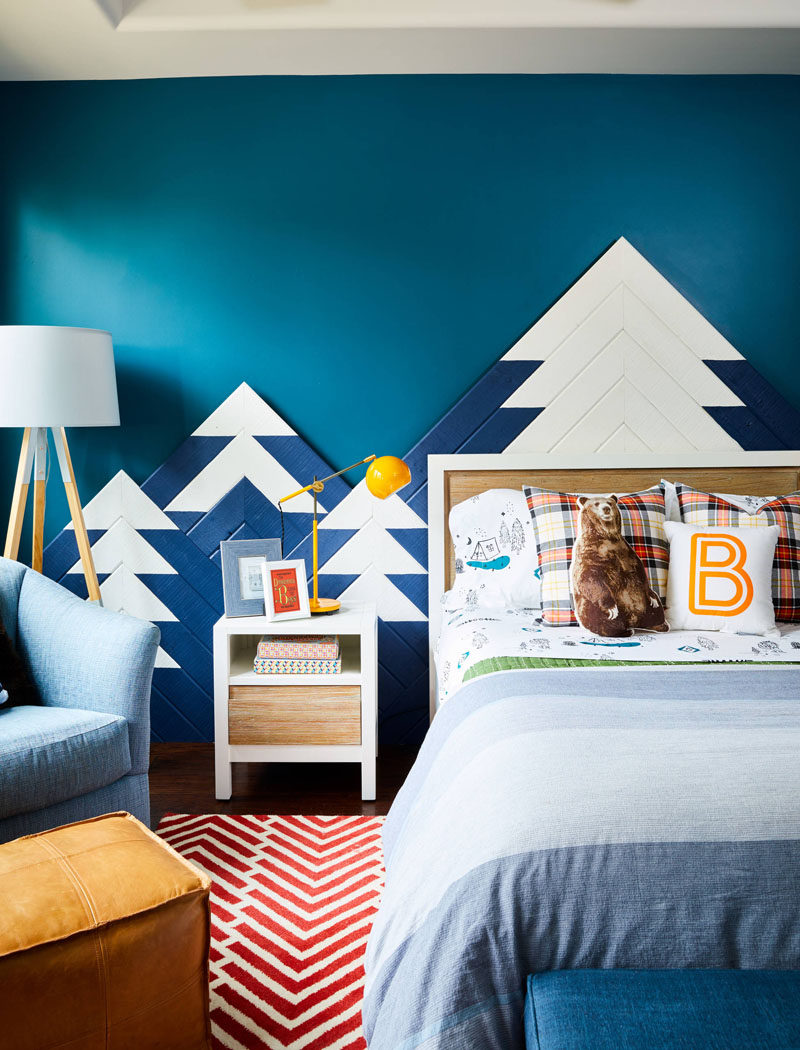 This kids bedroom design includes a mountain range as wall art, with hidden lighting that mimics the colors of the Northern Lights. 