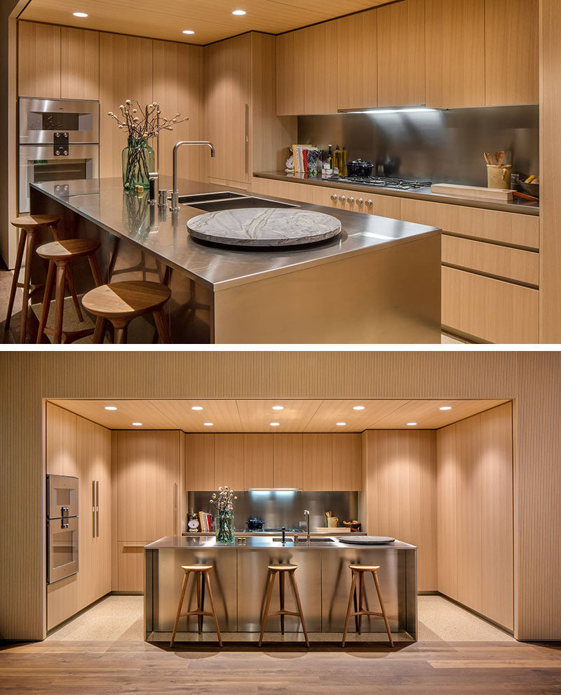 This modern kitchen features American oak cabinets with satin-finish stainless steel countertops and backsplashes. Dornbracht faucets have been used for the sink, and for the floor, mottled quartz has been used in the kitchen, while oil finished oak flooring has been used in the rest of the apartment.
