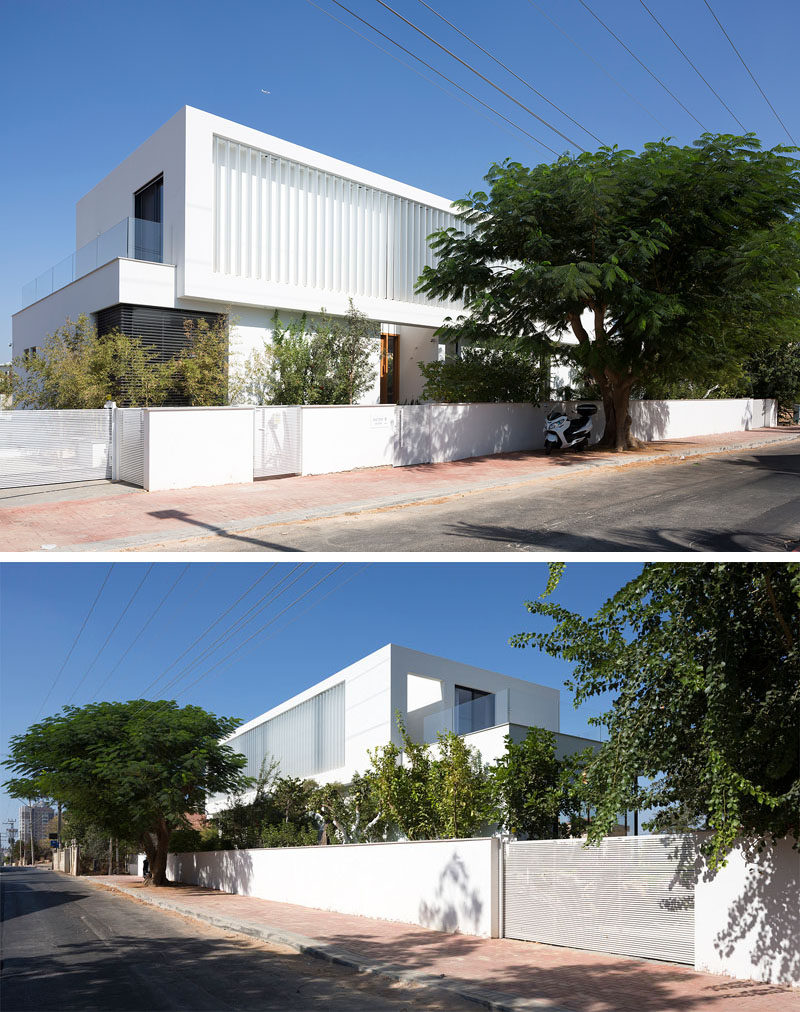 Designed as two separate boxes, one on top of the other, this white modern home has electrical vertical louvers on the top floor that can be easily opened when required.