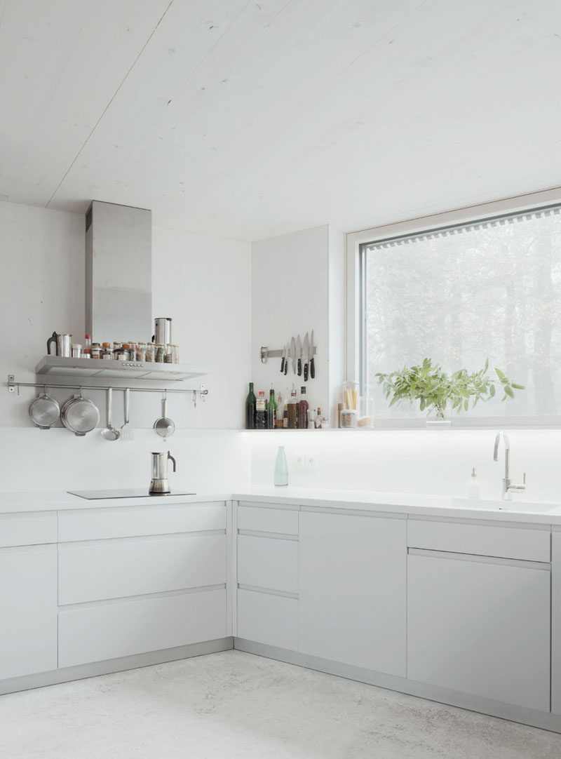 In this modern kitchen, white cabinets and hidden lighting have been used to keep the bright and airy.