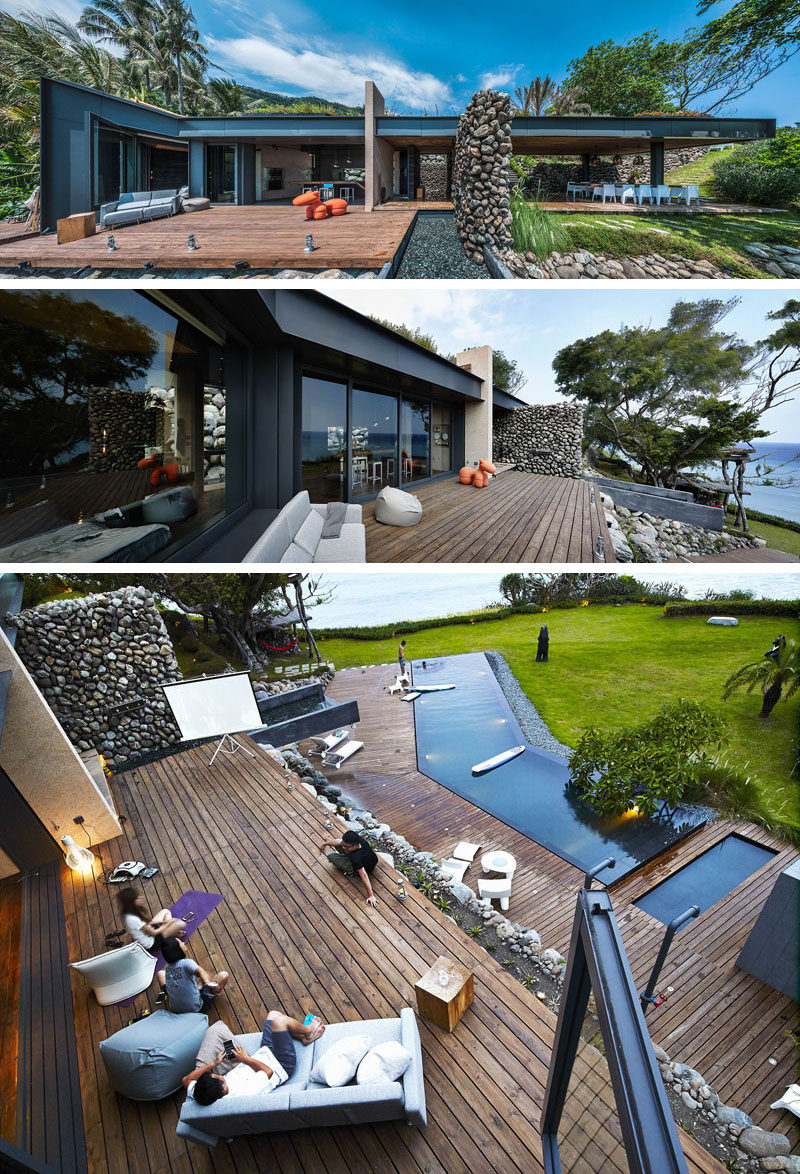 This modern house has an outdoor deck with a a water feature that turns into a waterfall on the lower level, home to an infinity swimming pool.