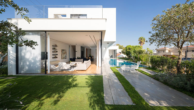 Shachar- Rozenfeld architects have designed this 'L' shaped modern home in Rishon LeZion, Israel, that sits on a narrow trapezoid lot and borders a small public park.