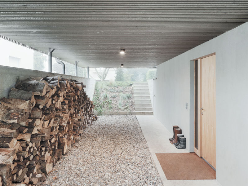 The carport underneath this modern provides access to the home and allows for firewood to be stored. Steps at the rear of the carport lead to the backyard.