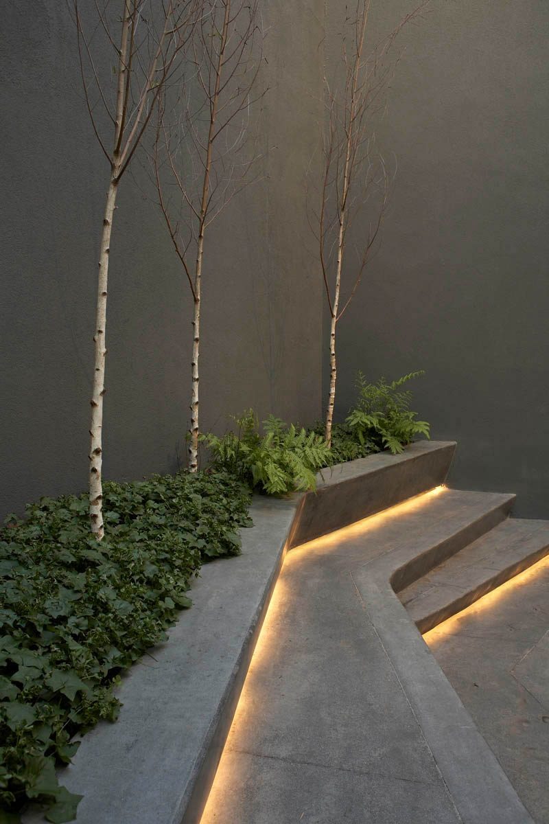8 Outdoor Lighting Ideas To Inspire Your Spring Backyard Makeover / Hidden LED Lighting - Placing LED strips along the base of your stairs or under furniture is a simple way to brighten up your backyard or garden and makes the space safer.