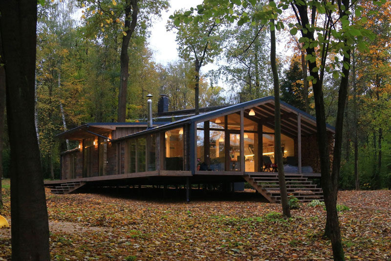 This rustic modern house in a forest has a modular design, with metal framing combined with barn board and glass to create a look that fits in with the surrounding environment.