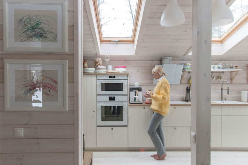 In the kitchen of this rustic modern house, light wood cabinets line the wall, while skylights flood the kitchen with natural light.