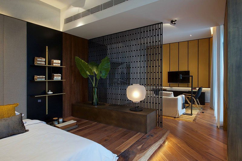 In this small apartment the living room and bedroom share the same area. The bedroom space was separated from the rest of the apartment by using a screen for a divider and placing the bed on a wood platform with hidden LED lighting.