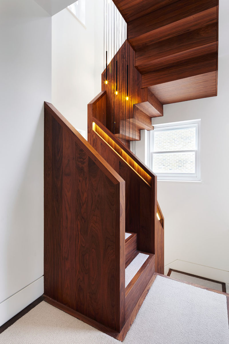 This American black walnut stairs has hidden lighting in the built-in handrails to light up the staircase and make the handrail easier to find.