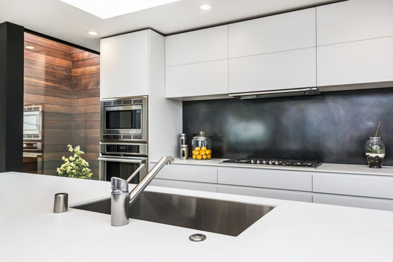 Kitchen Design Ideas - 9 Backsplash Ideas For A White Kitchen // Create a bit of contrast in your white kitchen with a super dark backsplash. Black tile is an easy way to do this but the look can also be achieved with a dark brushed metal or even a black glass.