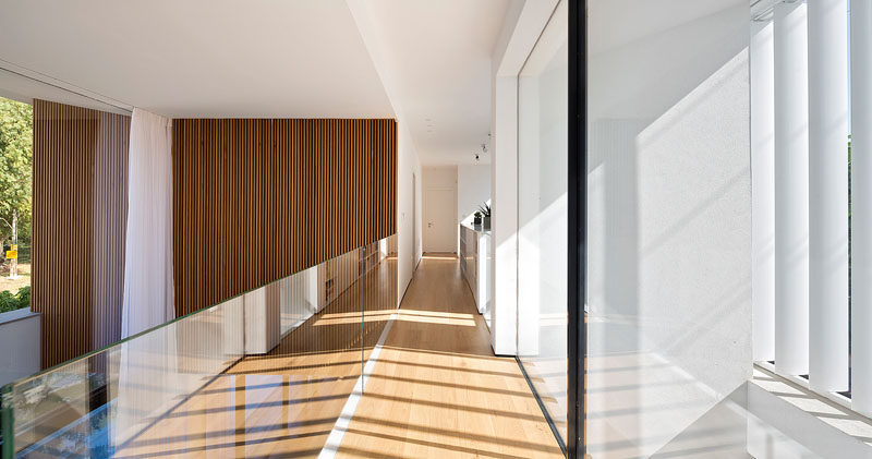 Upstairs in this modern house is a bridge that travels across the lobby overlooking the entrance and front door on one side, and the swimming pool on the other.