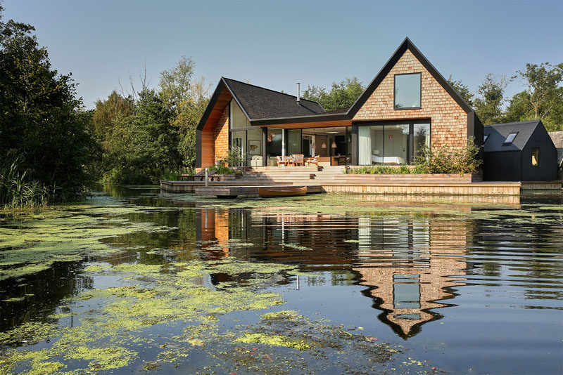 This new modern house covered in wood shingles has pitched roofs, a separate boat shed, sits beside a secluded lagoon and can also be rented out for vacation rentals.