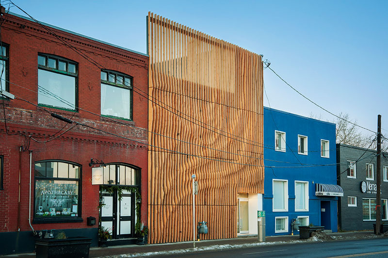 Using 100 year old fir reclaimed from an abandoned grain storehouse in Alberta, design firm MODA created a screen of 'fins' over top of the concrete exterior of this building.