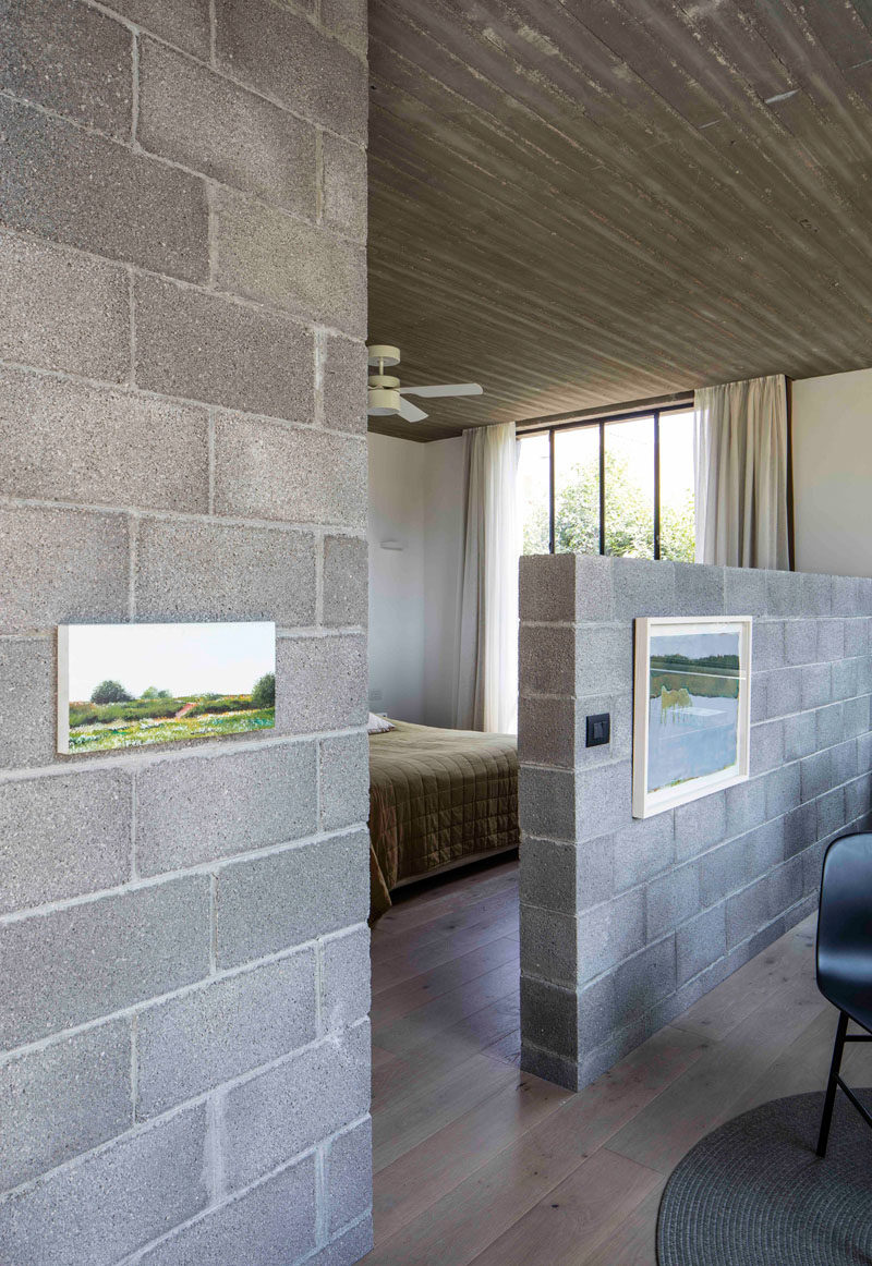 In this master bedroom there's a small sitting room separated from the bed by a pony wall made from concrete blocks.