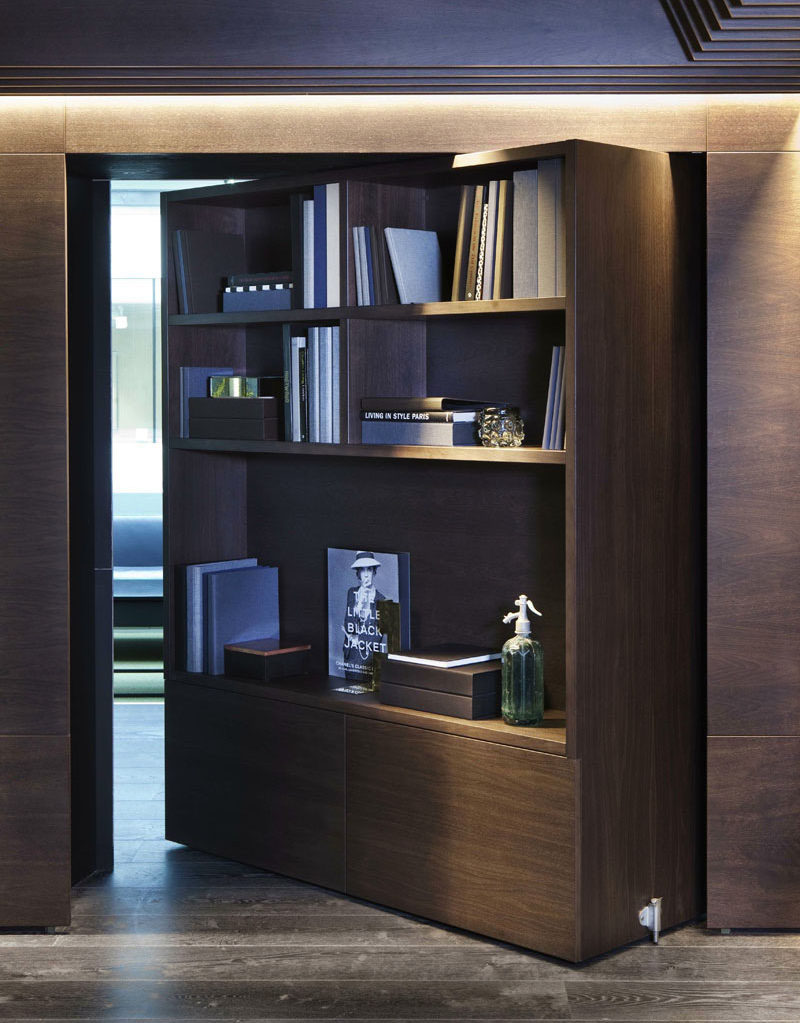 This large pivoting wood bookshelf in an office opens up to a hidden room and is a great way to make sure you aren't disturbed while doing important work.