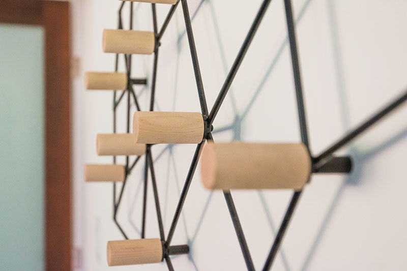 This geometric and modern wall-mounted coat rack could easily pass as wall art, and is made from a black metal frame that attaches to the wall, while wood pegs are positioned at the internal joints, creating a space to hang your jacket, scarf or bag.