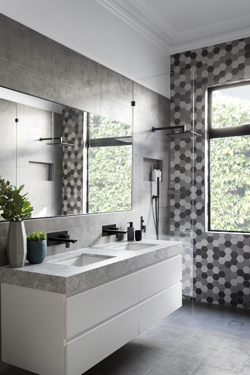 GIA renovations have created a modern grey and white bathroom with matte black accents, that proves you don't always need a lot of color in an interior.