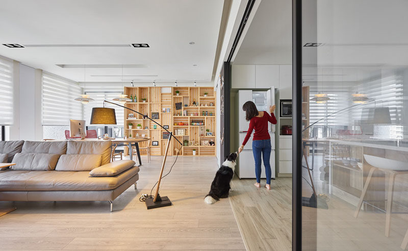 This modern apartment interior features a wall of wood crates that become a bookshelf and add storage to the room