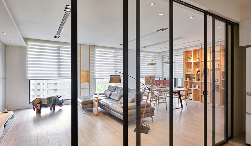 This modern apartment interior features a wall of wood crates that become a bookshelf and add storage to the room