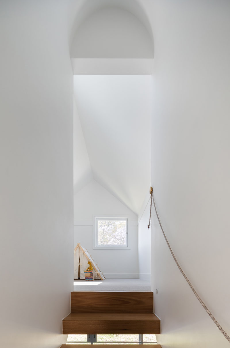 A landing at the top of these wooden stairs provides a bright spot perfect for playing, and features a small window looking out to the backyard below.