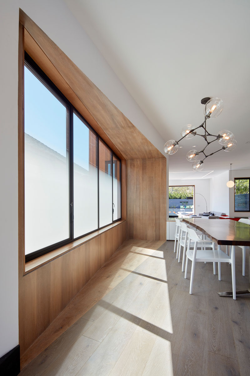 The windows that sit on the side of this modern house are partially opaque, providing privacy but at the same time allowing the light to shine through.