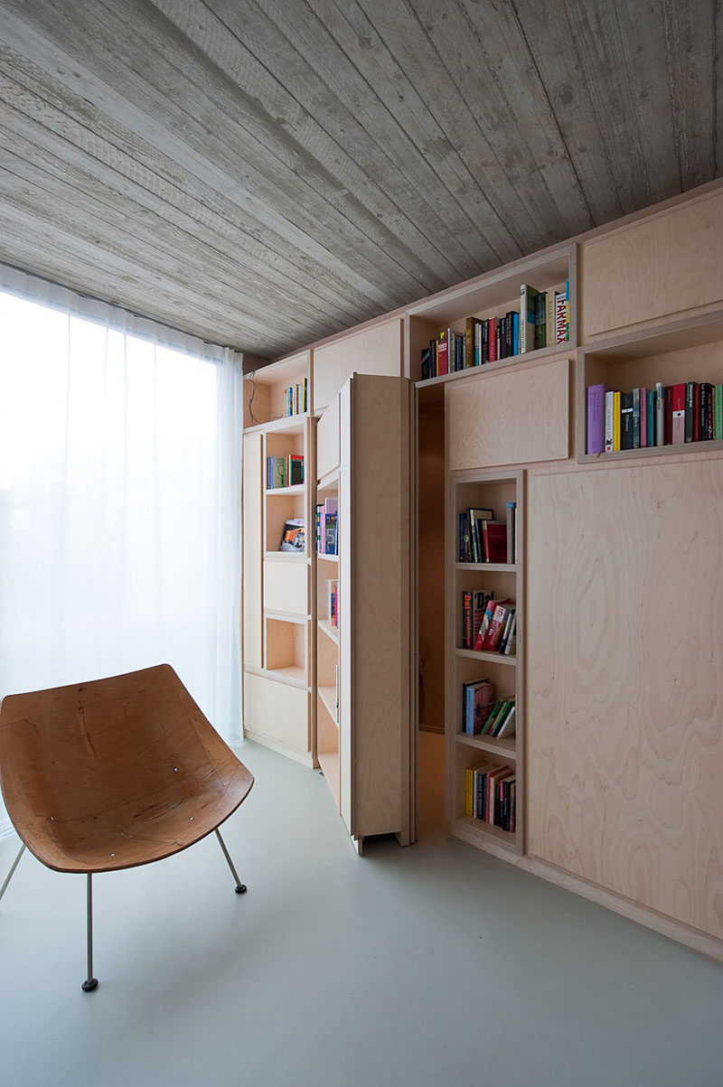  In this small modern house, a private room is hidden behind a wall of built-in bookshelves that can only be accessed by opening the secret door.