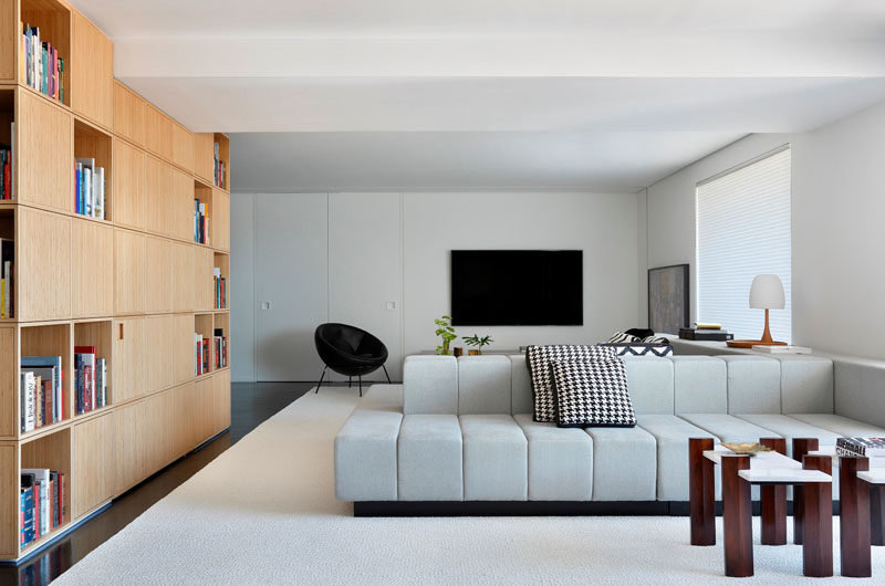 The living area of this modern apartment is divided into two sections by the centrally positioned double-sided couch. 