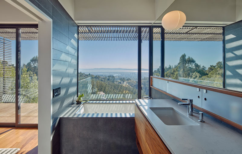 This modern bathroom with a large mirror features a built-in bath perfectly positioned to take advantage of the views.